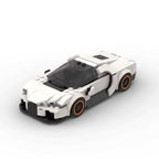 ELYTRA Cosmique, maquette d'hypercar blanche en briques Mabric™ aux jantes cerclées d'orange